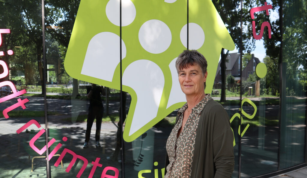 Anja Artz voor het kantoor van woningbouwvereniging Bergopwaarts in Deurne