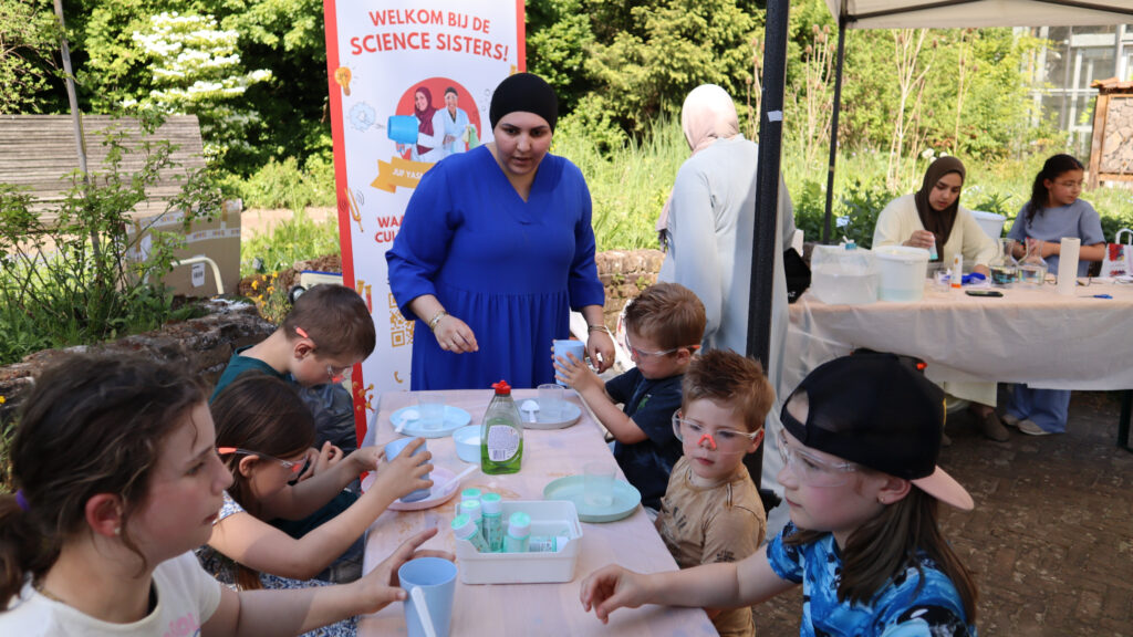 Kinderen doen proefjes tijdens educatief event. Science Sisters groeit in tijdelijke ruimte Livable.
