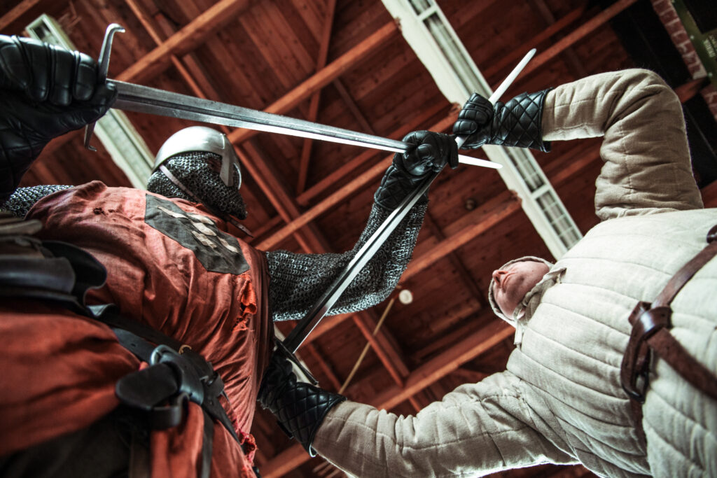 Leden van Bataille Krijgskunsten oefenen met zwaarden in leegstaand schoolgebouw in Woerden