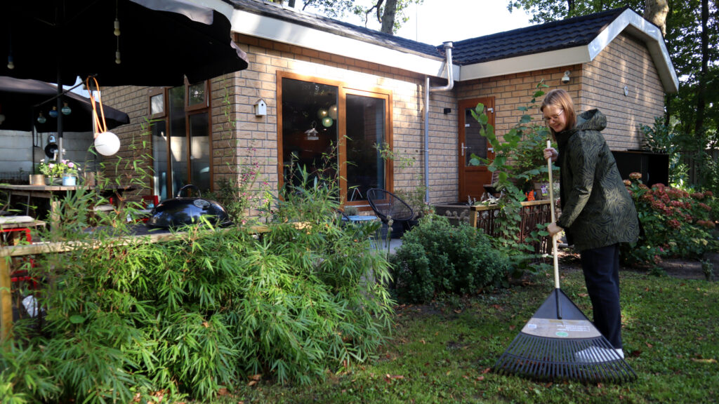 Julia werkt in de tuin van de bruikleenwoning, samen maken ze hun tijdelijke huis steeds meer eigen.